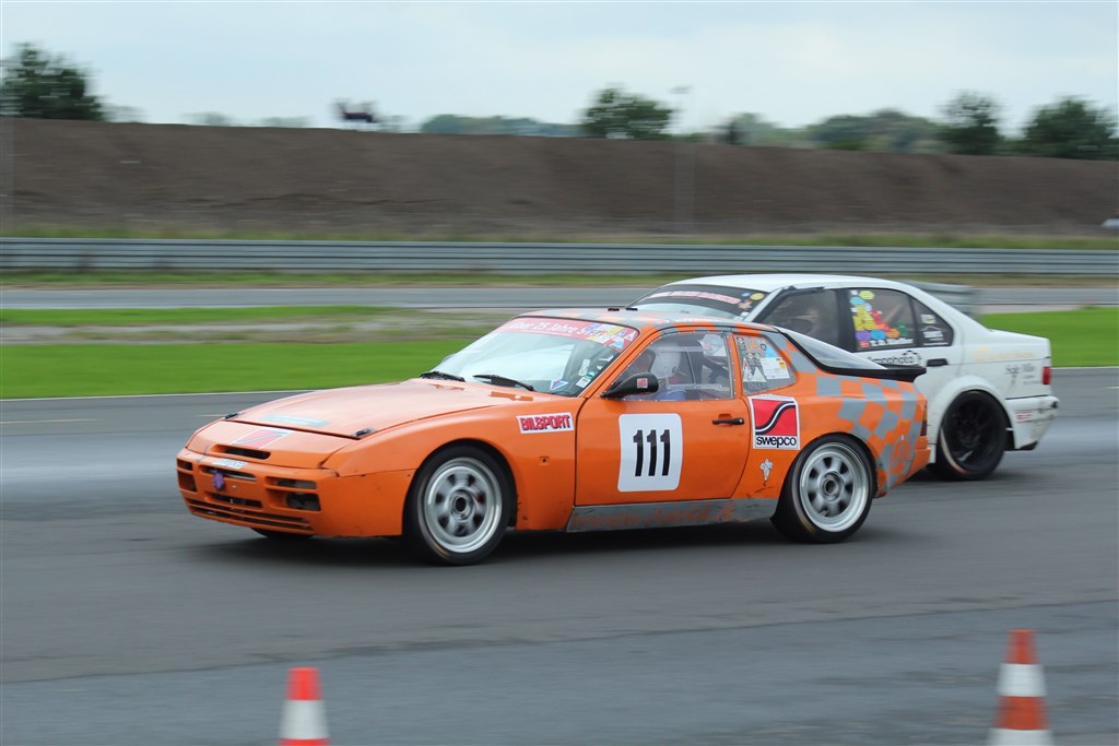 Peter Mikkelsen (111) blev weekendens store overraskelse i Division 1, for regnvejret var lige noget der passede den orange Porsche 944 S2. Her ses han i duel med, ikke Tommy Dam Kieffer, men Torben Nielsen, der havde lånt Kieffers BMW.
(Foto: JJ Media)